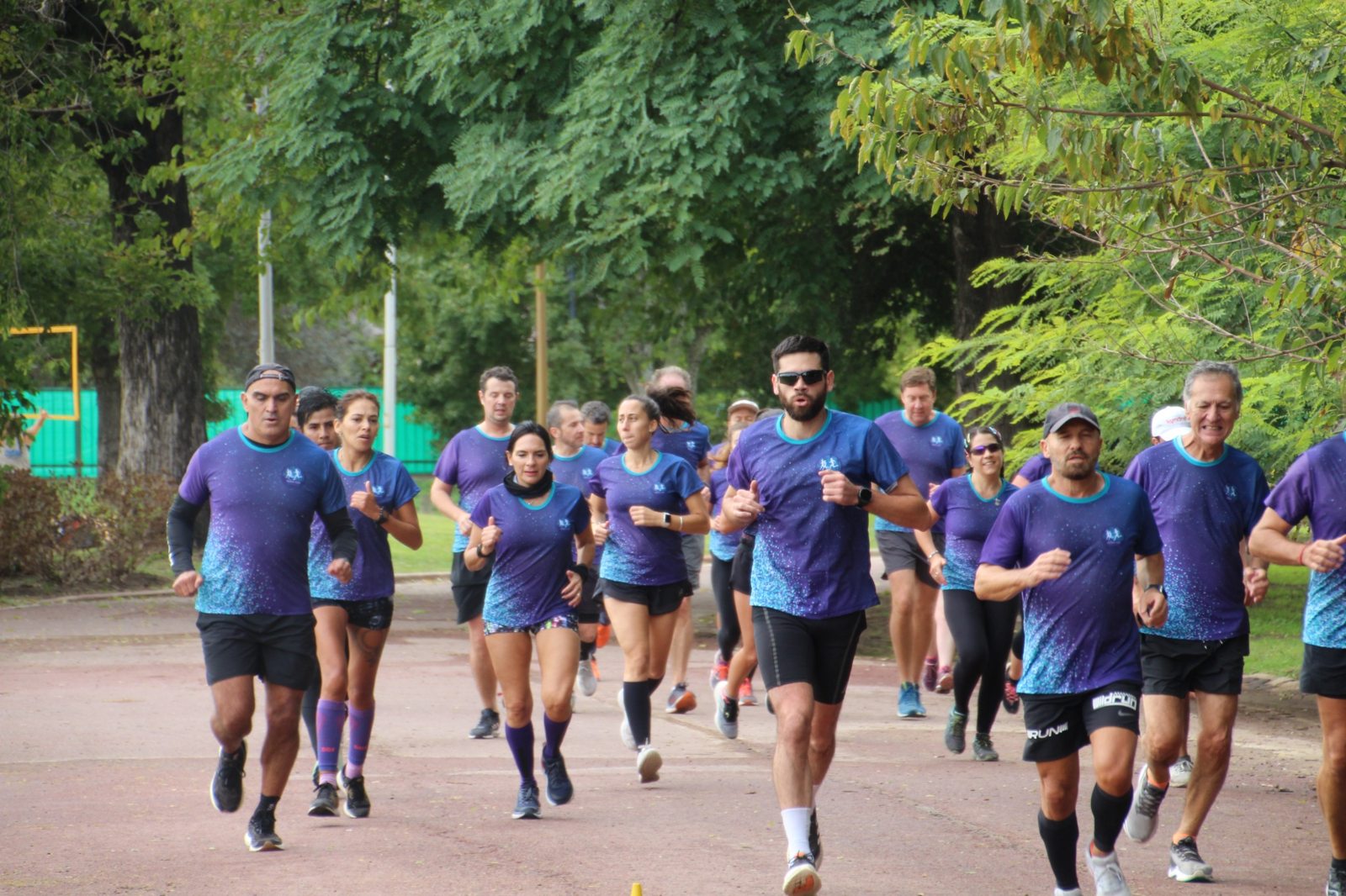 Integrantes de Club Pampa corriendo juntos en el parque